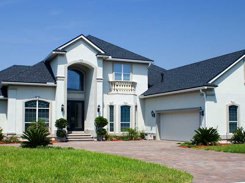 Higher-end, two-story white Florida home with a black shingle roof